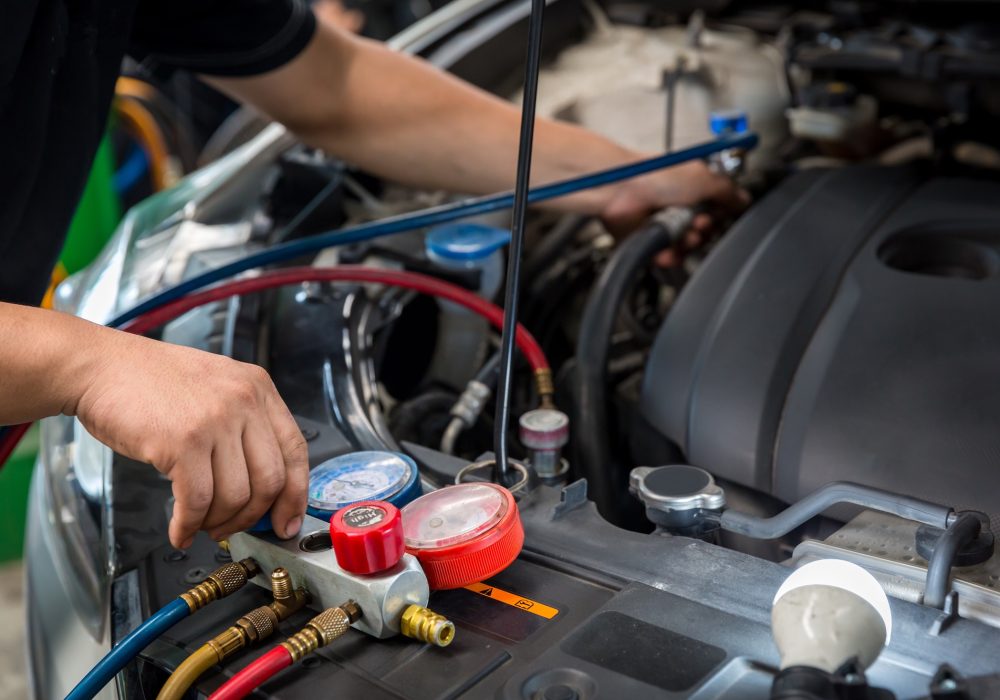 Auto mechanic monitor to check and fixed car air conditioner system in car garage. service car air conditioner in repair workshop. monitor tool on car engine ready to check and fixed air conditioner